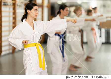 Women students repeat position and perform sequence of punches and painful techniques kata 133506626