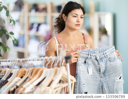 Undetermined young girl choosing jeans pantaloons in clothing store Undetermined young girl choosing jeans pantaloons in clothing store 133506789