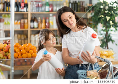 Child girl with mother choose consider milk snacks. 133506839