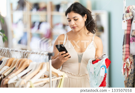 Young woman scanning qr code of panties in clothing store Young woman scanning qr code of panties in clothing store 133507058