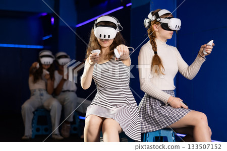 Female friends competing in two-on-two virtual reality game 133507152