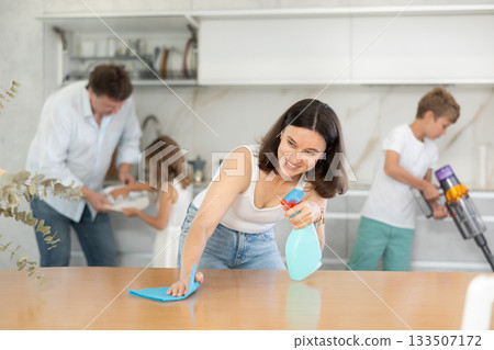 Happy family with two children doing cleaning in kitchen Happy family with two children doing cleaning in kitchen 133507172