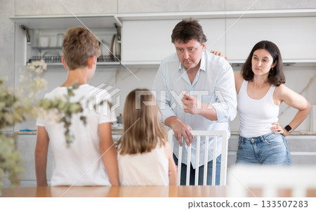 Father and mother, scolding little son and daughter for disobedience 133507283