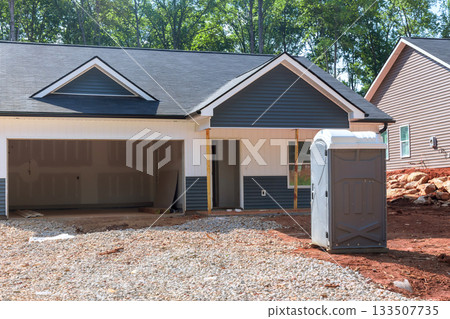 Construction ongoing at new house, exterior details, portable restroom on site. Construction ongoing at new house, exterior details, portable restroom on site. 133507735
