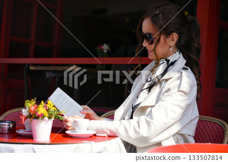 Woman reading at outdoor cafe in Paris with coffee Woman reading at outdoor cafe in Paris with coffee 133507814