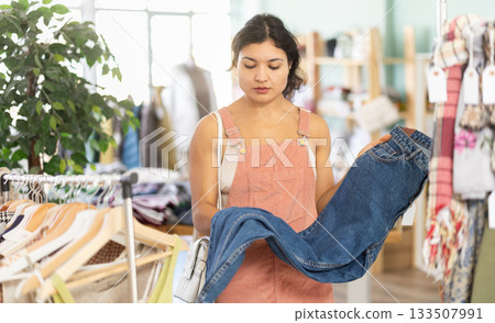 Young woman choosing jeans in clothing store 133507991