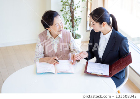 安寧療護計畫：一位老年婦女和諮商師正在填寫臨終關懷紀錄。 133508342