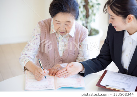 安寧療護計畫:一位老年婦女和諮商師正在填寫臨終關懷紀錄。 安寧療護計畫:一位老年婦女和諮商師正在填寫臨終關懷紀錄。 133508344