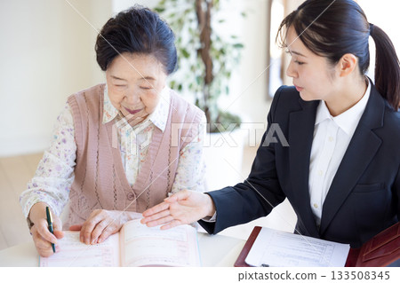 End-of-life planning: Senior woman and counselor filling out an end-of-life note End-of-life planning: Senior woman and counselor filling out an end-of-life note 133508345