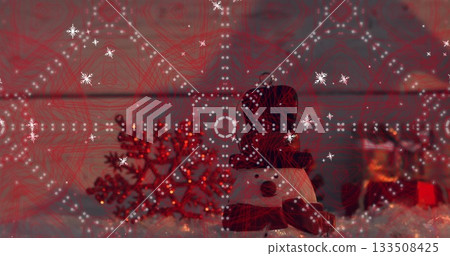 Displaying snowman figurine wearing black top hat, red scarf at home, with red snowflake ornament Displaying snowman figurine wearing black top hat, red scarf at home, with red snowflake ornament 133508425