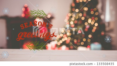 Displaying red Season's greetings graphic overlaying living room, with wooden tabletop and tree Displaying red Season's greetings graphic overlaying living room, with wooden tabletop and tree 133508435