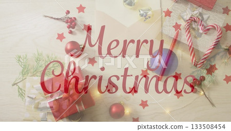 Showcasing red Merry Christmas script floating on light wood tabletop, with gift box and candy cane Showcasing red Merry Christmas script floating on light wood tabletop, with gift box and candy cane 133508454