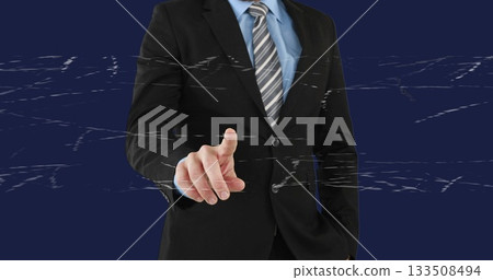 Pointing businessman wearing black suit, light blue shirt, striped tie at studio with glitch lines 133508494