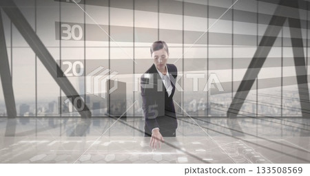 Businesswoman interacting with holographic table in high-rise office, with digital graphs 133508569