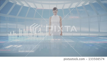 Operator in uniform examining holographic charts on table in control room, with translucent panels 133508574
