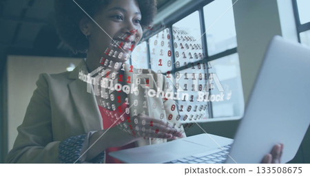 Presenting woman in blazer gesturing at rotating blockchain globe hologram in office holding laptop Presenting woman in blazer gesturing at rotating blockchain globe hologram in office holding laptop 133508675