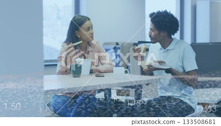 Chatting coworkers eating lunch in office break room, with takeout box, chopsticks and fork 133508681