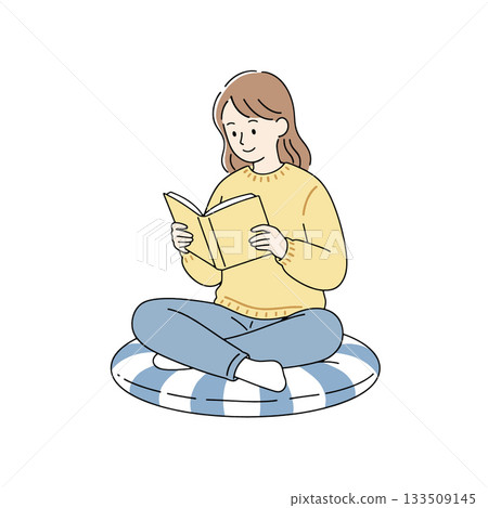 Young woman reading book sitting cross legged on cushion, relaxed and focused 133509145