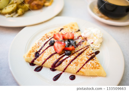 Sweet Dessert Crepe with Berries, Syrup, and Whipped Cream Sweet Dessert Crepe with Berries, Syrup, and Whipped Cream 133509663