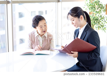 安寧療護計畫:一位老年婦女和諮商師正在填寫臨終關懷紀錄。 安寧療護計畫:一位老年婦女和諮商師正在填寫臨終關懷紀錄。 133509681