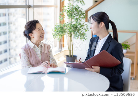 安寧療護計畫:一位老年婦女和諮商師正在填寫臨終關懷紀錄。 安寧療護計畫:一位老年婦女和諮商師正在填寫臨終關懷紀錄。 133509686