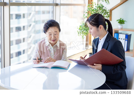 安寧療護計畫：一位老年婦女和諮商師正在填寫臨終關懷紀錄。 133509688