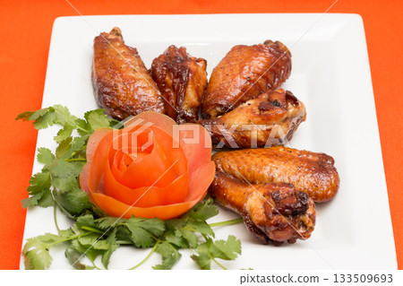 Barbecue Glazed Chicken Wings with Tomato Garnish Barbecue Glazed Chicken Wings with Tomato Garnish 133509693