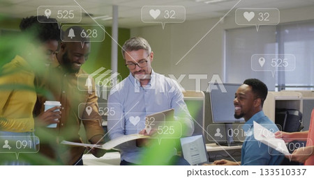 Pointing team lead in blue shirt reviewing documents in office, with social media icons 133510337
