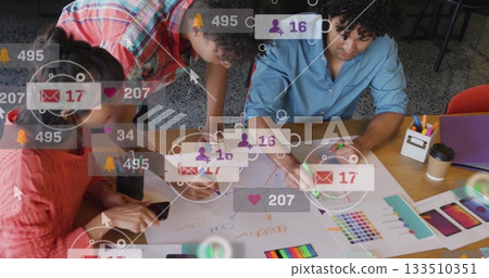 Collaborating professionals sketching UI mockups at table with smartphone, color swatches, markers 133510351