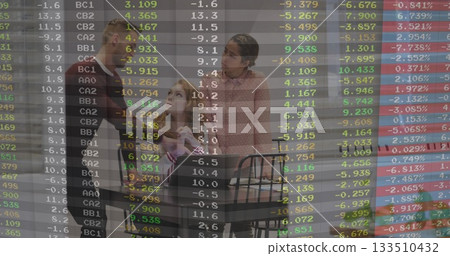 Family of three gathering at wooden table in kitchen, with spiral notebooks, mugs and data overlay 133510432