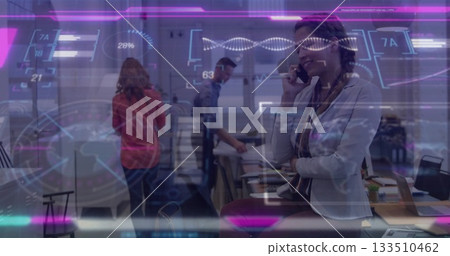 Leaning professional woman speaking on smartphone in tech office, with holographic data projections Leaning professional woman speaking on smartphone in tech office, with holographic data projections 133510462