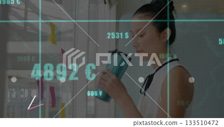 Asian woman in blouse holding mug analyzing currency figures on sticky notes in office, copy space Asian woman in blouse holding mug analyzing currency figures on sticky notes in office, copy space 133510472