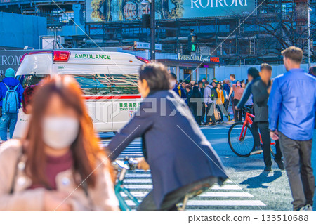 日本東京的都市景觀。一輛救護車緩慢行駛……人們透過麥克風絕望地呼喊司機，但司機置之不理，日本民眾聚集在十字路口。 133510688
