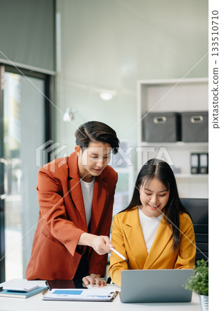 Businesswomen work and discuss their business plans. A Human employee explains and shows her colleague the results paper Businesswomen work and discuss their business plans. A Human employee explains and shows her colleague the results paper 133510710
