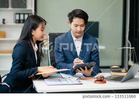 Asian business team and lawyers discussing contract papers sitting at the table. Concepts of law, advice, legal services. 133511060