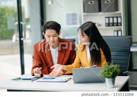 Businesswomen work and discuss their business plans. A Human employee explains and shows her colleague the results paper 133511066