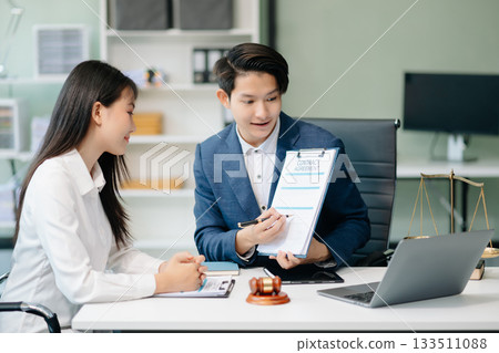 Asian business team and lawyers discussing contract papers sitting at the table. Concepts of law, advice, legal services. 133511088