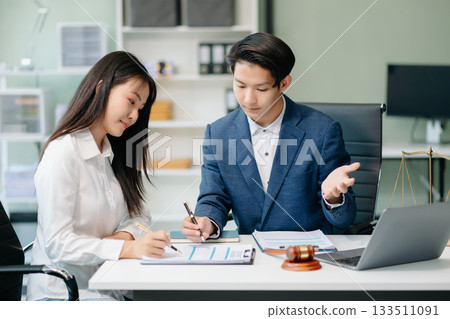 Asian business team and lawyers discussing contract papers sitting at the table. Concepts of law, advice, legal services. 133511091