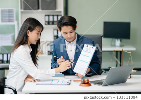 Judge gavel with scales of justice, Business and lawyer or counselor consulting and discussing contract papers with laptop and tablet at law firm Judge gavel with scales of justice, Business and lawyer or counselor consulting and discussing contract papers with laptop and tablet at law firm 133511094