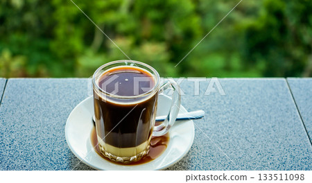 close-up photo of a glass of coffee with milk 133511098