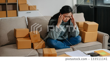 woman using smartphone or tablet taking receive and checking online purchase shopping order to preparing pack product box. 133511141