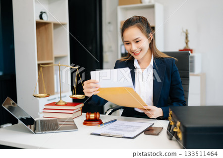Asian lawyer woman working with a laptop and tablet in a law office. Legal and legal service concept. Asian lawyer woman working with a laptop and tablet in a law office. Legal and legal service concept. 133511464