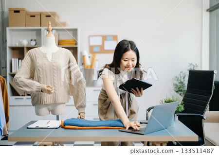 fashion designer. Attractive woman with smile while standing in workshop. Beautiful owner woman working 133511487