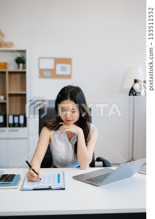 Asian businesswoman working in the office with working notepad, tablet and laptop 133511552