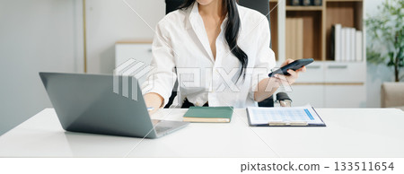 businesswoman working at office with laptop, tablet and taking notes on the paper. businesswoman working at office with laptop, tablet and taking notes on the paper. 133511654