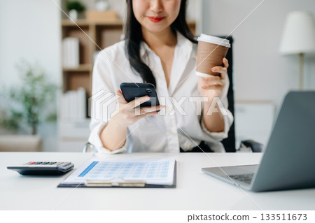 businesswoman working at office with laptop, tablet and taking notes on the paper. 133511673