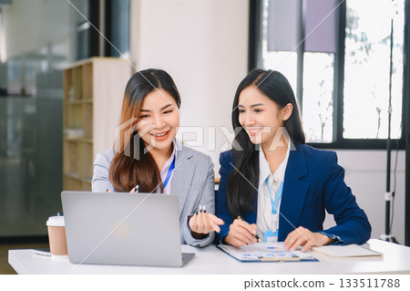 Asian business colleague business presents and explains and using laptop and tablet. Teamwork, financial marketing team, 133511788