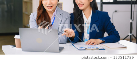 Asian business colleague business presents and explains and using laptop and tablet. Teamwork, financial marketing team, 133511789