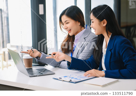 Asian business colleague business presents and explains and using laptop and tablet. Teamwork, financial marketing team, Asian business colleague business presents and explains and using laptop and tablet. Teamwork, financial marketing team, 133511790