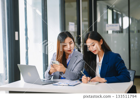 Asian business colleague business presents and explains and using laptop and tablet. Teamwork, financial marketing team, 133511794